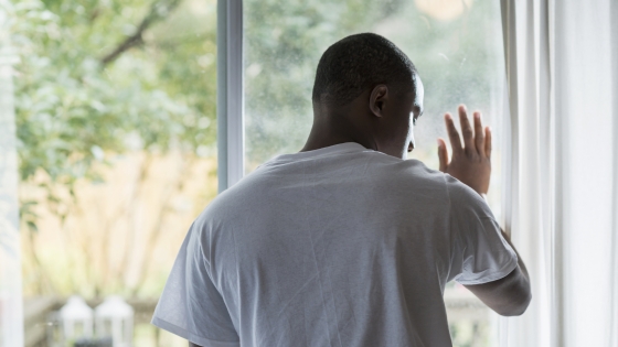 black man standing at window