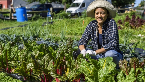 Young woman kneeling in urban garden