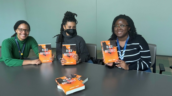 Three Health Equity Scholars hold a copy of the book The Black Butterfly