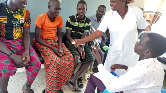 Health worker showing MMS tablet in Karamoja region, Uganda. Photo by Rebecca Birungi