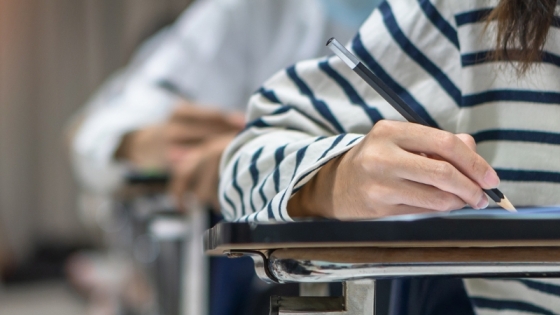 A student writing at a desk
