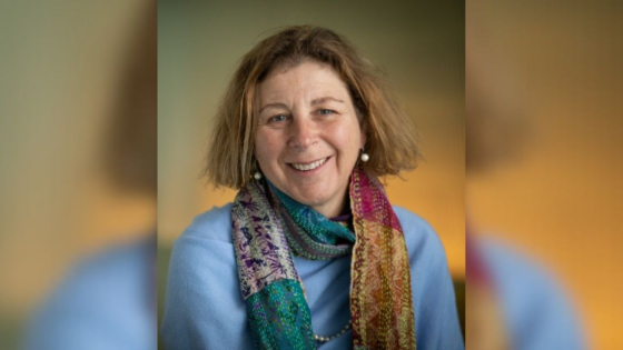 A headshot of a smiling woman with short dirty blonde hair