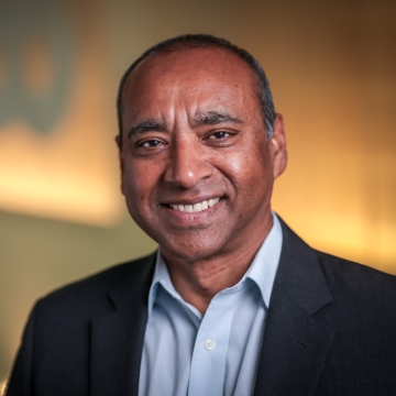 head shot of a man in a blue shirt and suit jacket