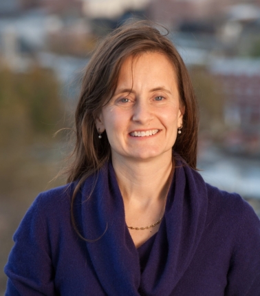 A headshot of a woman wearing a blue sweater