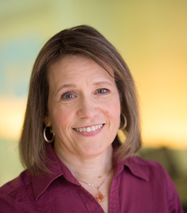 Smiling person with brown hair and blue eyes