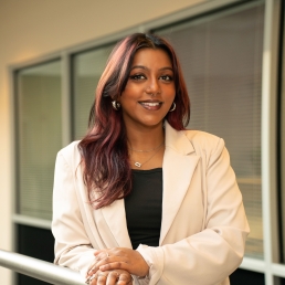 Suzanna Arul smiles for a professional photo in the 2024 E. Monument Street building.