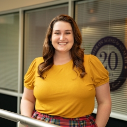 Katie Caviness-Crolley smiles for a professional photo in the 2024 E. Monument Street building.