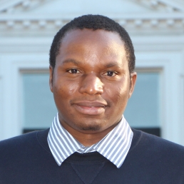 head shot of a man in front of a building