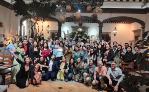 A large group of people posed for a photo in a hotel lobby