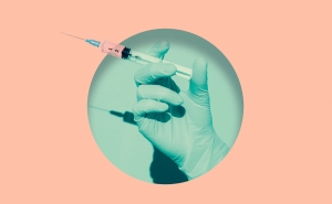 A doctor's gloved hand holding vaccine syringe placed inside a round hole of teal, background is salmon pink