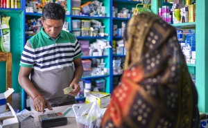 A pharmacist attends to a customer in an Indian pharmacy.