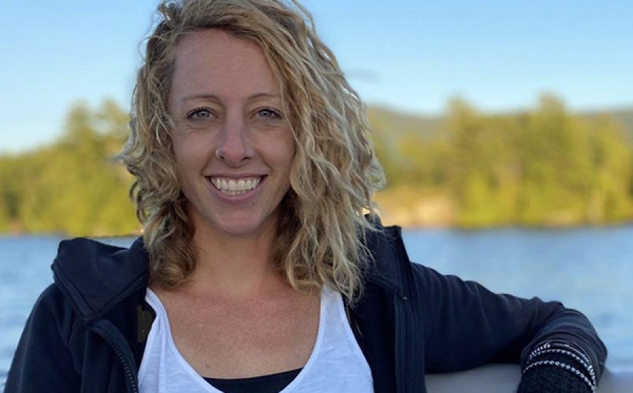 Jennifer O'Keeffe stands lakeside, with a beautiful blue sky behind her.