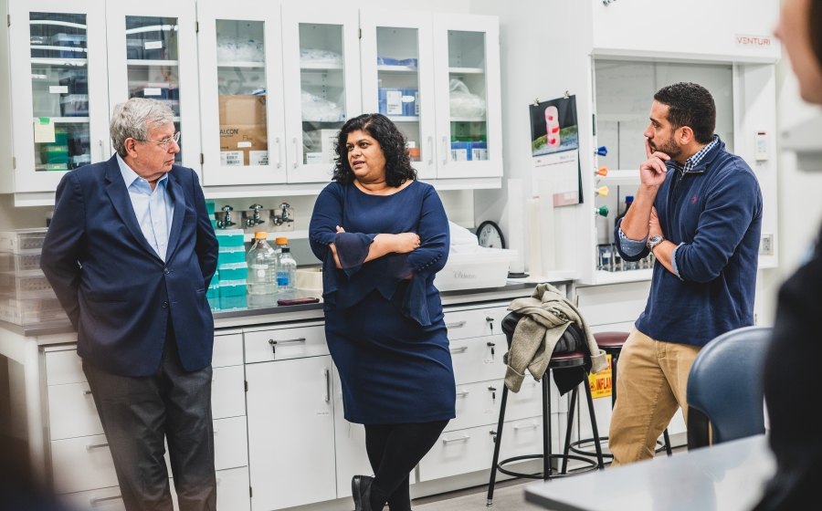 Professors Rebecca and Weeraratna chat with Bob Adler in a lab