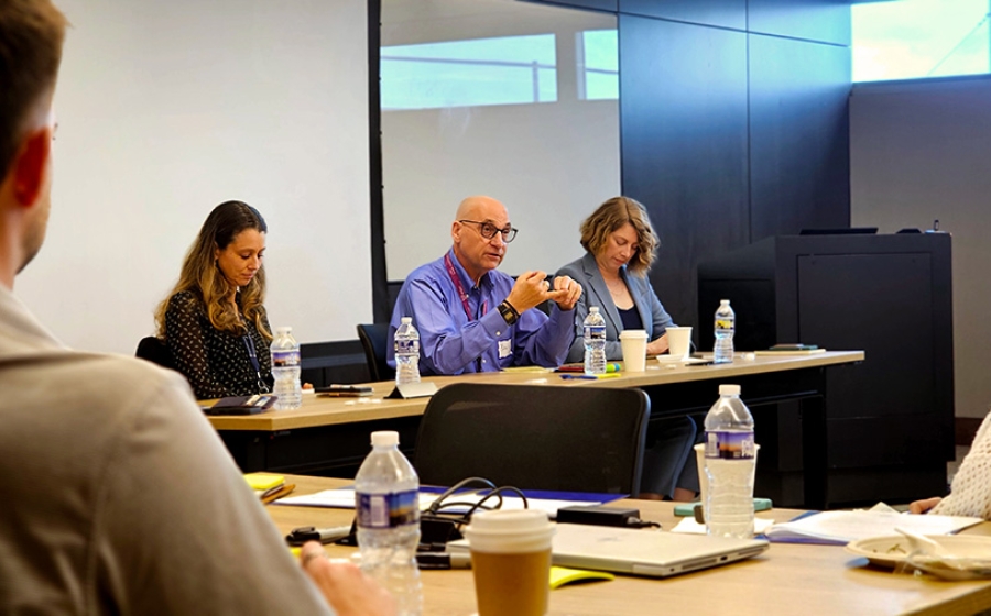 Man talking at a table next to two women