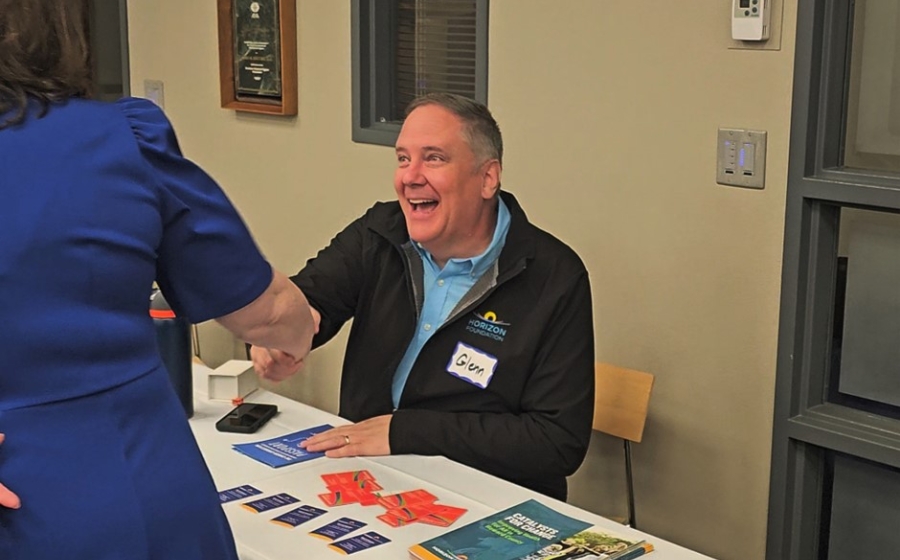 Man sitting at table shaking woman's hand