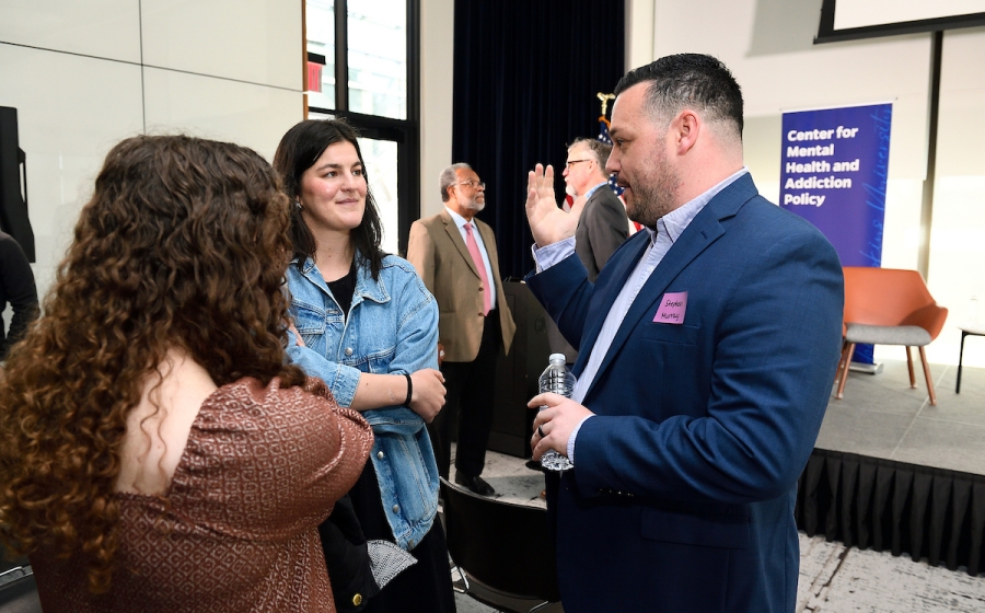 Adults converse among a crowd.