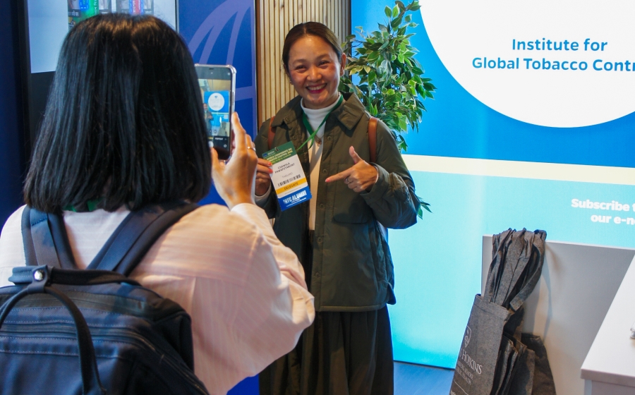 A woman in a green jacket poses for a picture