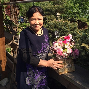 Dr. Kim holds a floral arrangement while standing outside at her home in Seoul, South Korea