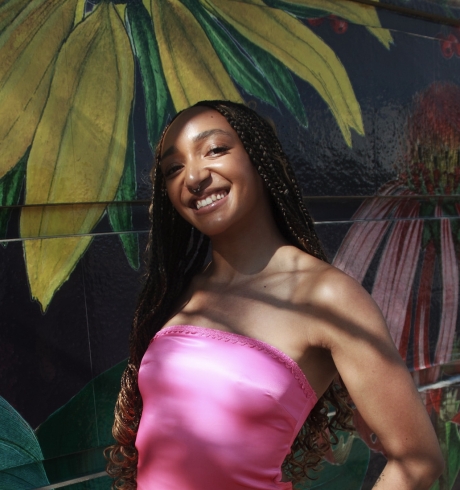 Mackenna Lindsay stands in front of a mural