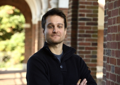male faculty standing outside college campus