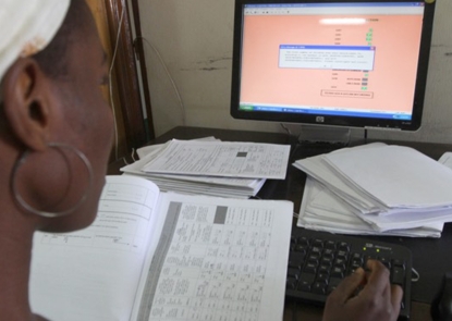 Recent Publications, woman using a computer and books to do research