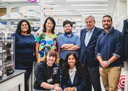 Faculty and students pose for photo in lab