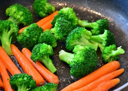 Broccoli and carrots rest in a pan.