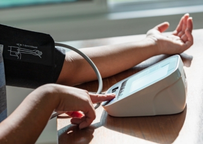 Person measures blood pressure using at-home cuff.