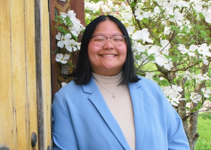 Photo of Allison Zhang wearing a light blue jacket over a white top.