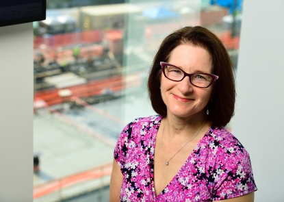 HBS department chair Joanna Cohen stands in front of a window overlooking the South Building construction site