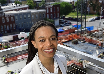 Pamela Collins stands with the South Building construction site in the backgroundr