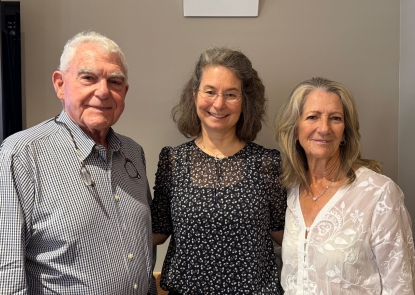 Two older adults, Roger and Flo Lipitz, stand and smile for a photo with Jennifer Wolff, director of the Lipitz Center